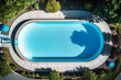 Swimming pool in summer at villa or hotel, top drone view