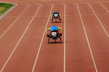 Wall Mural - two athletes in wheelchair racing race track stadium in para athletics championship, summer sports games