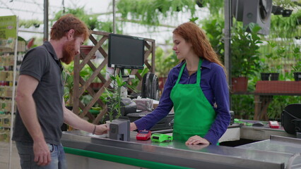 Wall Mural - Client Using Phone for Contactless Payment at Horticulture Store Checkout. Plant Purchase at Local Flower Shop