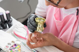 Fototapeta Pomosty - close-up of a girl using a nail stamper to place the stamps on her nails