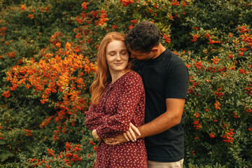 Wall Mural - Portrait of young cute couple embracing in nature.