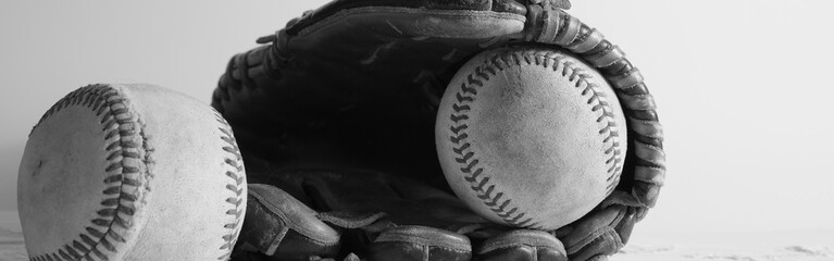 Wall Mural - Retro style black and white still life banner scene of used baseballs with ball glove background.