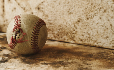 Sticker - Old vintage used baseball with torn seams on grunge brown background with copy space.