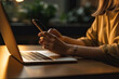 © pariketan - Woman work with smartphone and laptop computer on table in workplace
