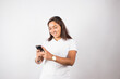 © artrolopzimages - photograph of latina woman using cell phone on a photo studio background. Concept of people and technology.