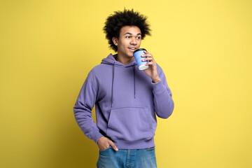 Wall Mural - Smiling African American man wearing stylish hoodie, holding cup of coffee