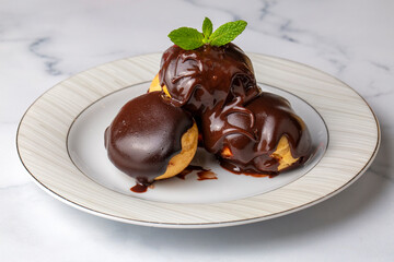 Wall Mural - Delicious profiteroles with chocolate and white plate.