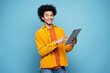© Maria Vitkovska - Smiling African American man holding digital tablet isolated on blue background