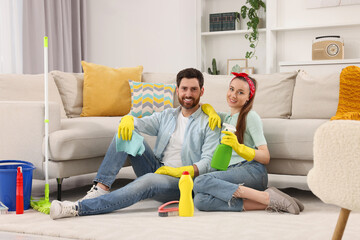 Canvas Print - Spring cleaning. Couple with detergents and mop in living room