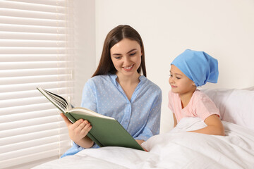 Canvas Print - Childhood cancer. Mother and daughter reading book in hospital