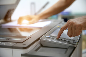 Photocopier printer, Close up hand office man press copy button on panel to using the copier or photocopy machine for scanning document or printing paper or Xerox a sheet.