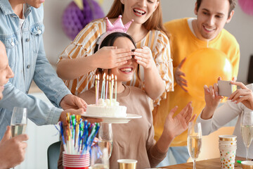 Wall Mural - young man bringing birthday cake to his friend at party