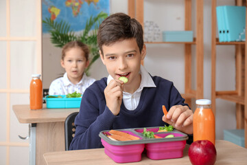 Canvas Print - Little boy eating lunch in classroom