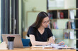 © Songsak C - Asian businesswoman working in piles of paper files to find and review unfinished documents in the financial document folder business agreement on the desk in the office.