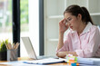 © Phimwilai - Cropped image of asian businesswoman analyzing paperwork using laptop to actively search for information tense expressions at the office.