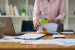 © Phimwilai - Asian businesswoman working in piles of paper files Documents in the meeting to search and review the various work folders at the desk to record information. management concept