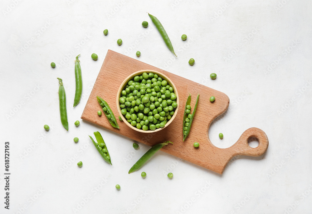 Bowl and wooden board with fresh green peas on white background