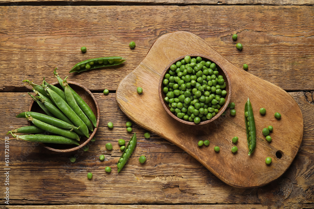 Bowls and board with fresh green peas on wooden background