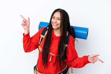 Wall Mural - Hiker teenager girl with braids over isolated white background pointing finger to the laterals and happy