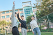 © TEAM PRE-LIGHT - Three young male and female college models walk with a ball and raise their hands in celebration after a game at a fall college futsal field in South Korea, Asia.