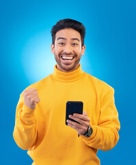 Aufkleber - Winner, excited and portrait of Asian man with phone in studio for online bonus, competition and prize. Success, smartphone and male person celebrate on blue background for promotion, winning or news