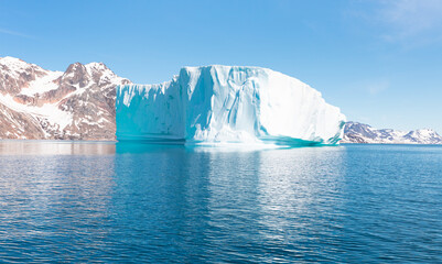 Melting icebergs by the coast of Greenland, on a beautiful summer day - Melting of a iceberg and pouring water into the sea - Greenland