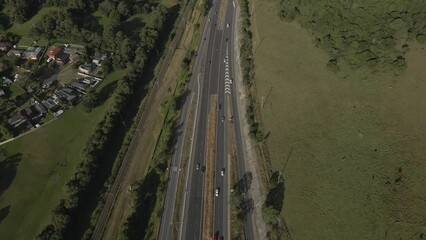 Poster - Aerial of cars driving on the road alongside the green fields and trees