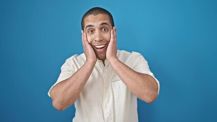 Poster - Young hispanic man standing with surprise expression over isolated blue background