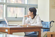 © TEAM PRE-LIGHT - Autumn scenery outside a window in South Korea, Asia, with a young female college student model sitting at a library desk, looking at a laptop, listening to a lecture or studying