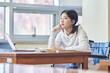 © TEAM PRE-LIGHT - Young handicapped female college student model with disability sitting in wheelchair and reading book in library of Asian Korean university