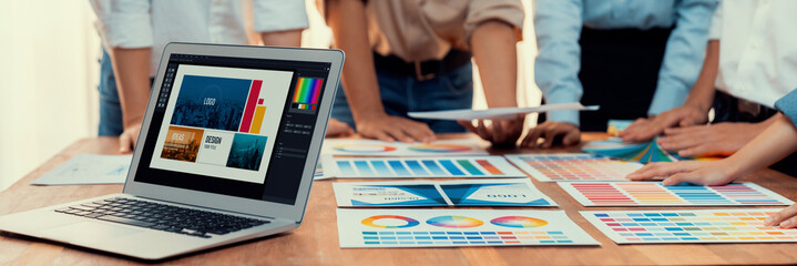 Poster - Graphic designer brainstorming logo and graphic art at busy artistic workshop, laptop display workspace. Experimenting color palette and pattern for creative design. Panorama shot. Scrutinize
