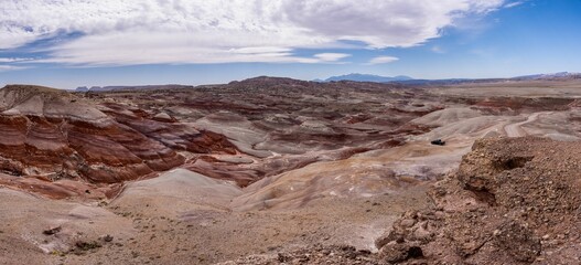 Sticker - Scenic desert landscape with hills and a bright blue sky with white clouds scattered throughout