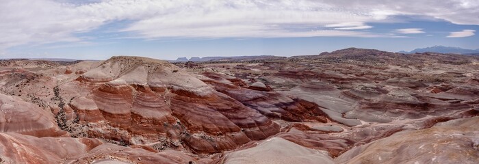 Sticker - Scenic desert landscape with hills and a bright blue sky with white clouds scattered throughout