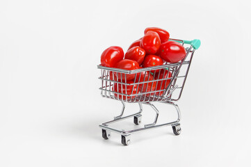 Wall Mural - tomatoes in a shopping cart on a light background