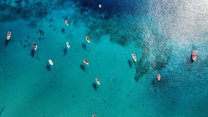 Canvas Print - Aerial shot of a number of boats leisurely sailing in the magnificent blue waters of a tranquil bay.