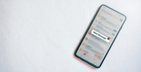 Banner of a smartphone with a new message notification on screen and white texture background. Communication business technology. Inbox view. New e-mail on mobile smartphone.