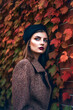 © Eduardo Lopez - Generative AI illustration of Beautiful young caucasian woman with background of red leaves in autumn colors dressed in the latest fashion
