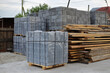 Paving stone pack in cellophane on wooden pallets for house building. Stack of concrete blocks.