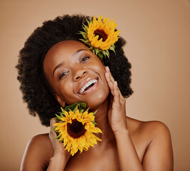 Poster - Portrait, skincare and sunflower with a model black woman in studio on a brown background for cosmetics. Face, beauty or natural and a happy young female person with a flower in her afro hair