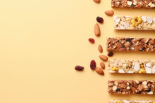 Top View Of Various Healthy Granola Bars, Muesli, Cereal, Nuts. Set Of Energy, Sport, Breakfast And Protein Bars Isolated On Pastel Orange Background. Copy Space For Text. Generative AI Photo.