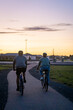 silhouette of two people riding a bike