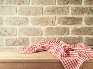 Wall Mural - Empty wooden table with tablecloth over brick wall  background. Kitchen mock up for design and product display