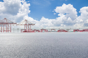 Wall Mural - Empty asphalt road and container port background