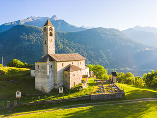 Aerial view of a church in Rossura in Switzerland during a sunset in a summer day, Rossura, Faido, Leventina, Switzerland