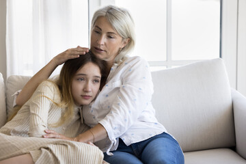 Wall Mural - Compassionate grandmother consoling sad teenage grandkid girl, hugging kid with love, giving comfort, family support, empathy, talking to child, discussing problem, depression