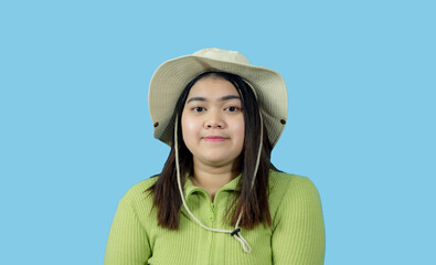 Wall Mural - Portrait girl young woman asian chubby fat cute beautiful pretty one person wearing a green shirt hat is sitting smiling enjoy happily looking wow to copyspace imaginary on the blue background