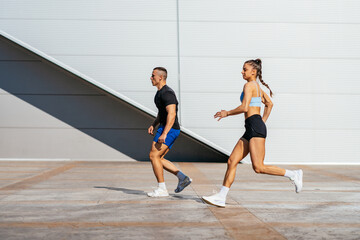 Wall Mural - Beautiful sporty couple running outside