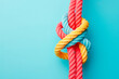 © Jezper - Top view of colorful ropes tied together on light blue background, space for text