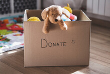 Donation Cardboard Box With Childrens Clothes And Toys, Charity And Volunteering Concept
