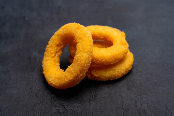 Wall Mural - Fried onion rings on black  background